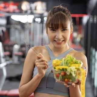 Woman eating healthy food at the gym