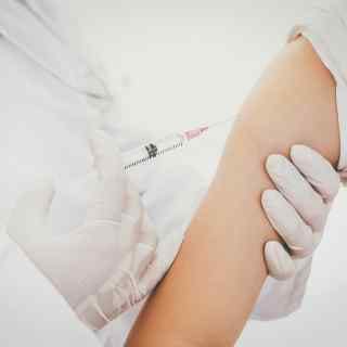 Woman getting travel vaccine in upper arm